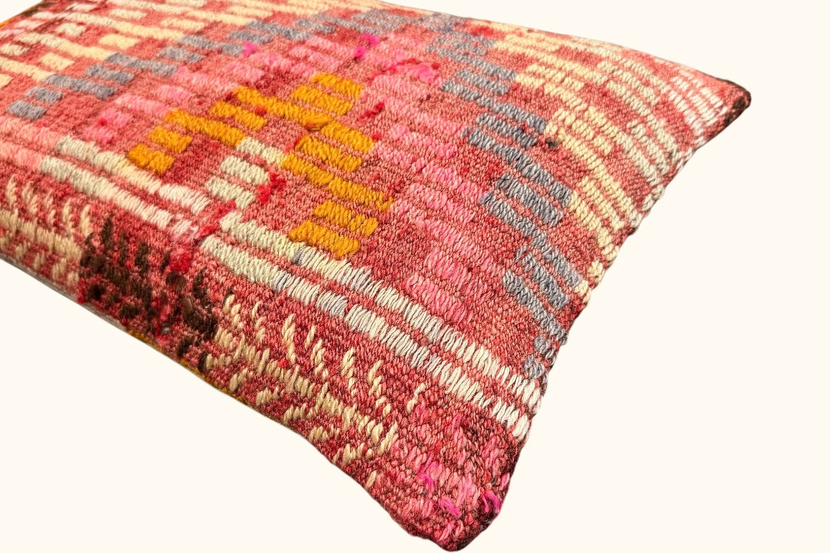 Detailaufnahme des handgewebten Kelim-Kissens – feine Struktur in Rosé- und Ockertönen