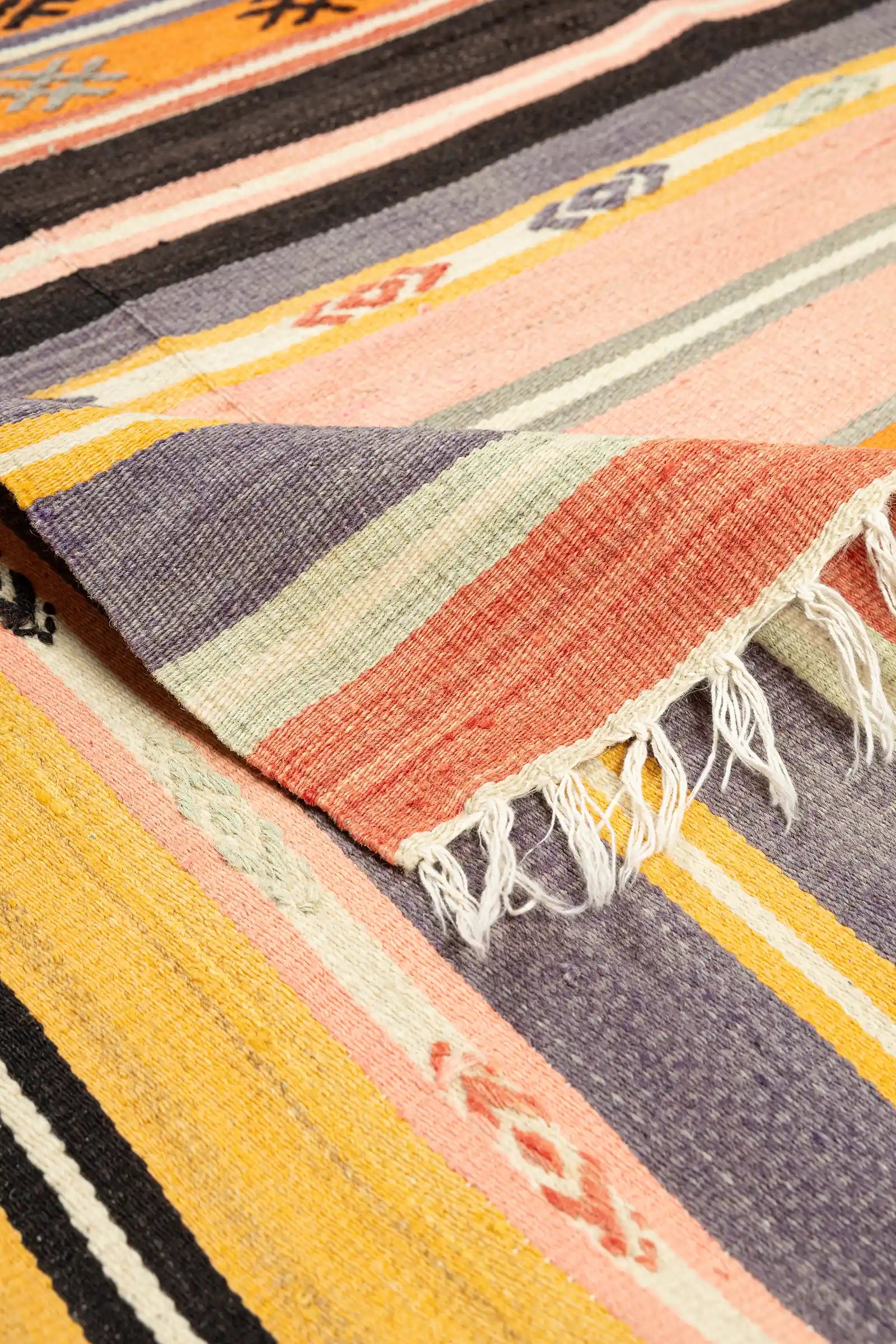 Vorder- und Rückseite des Kelims im Vergleich – Rückseite mit authentischem Webbild, Fransenabschluss mit leichter Unregelmäßigkeit