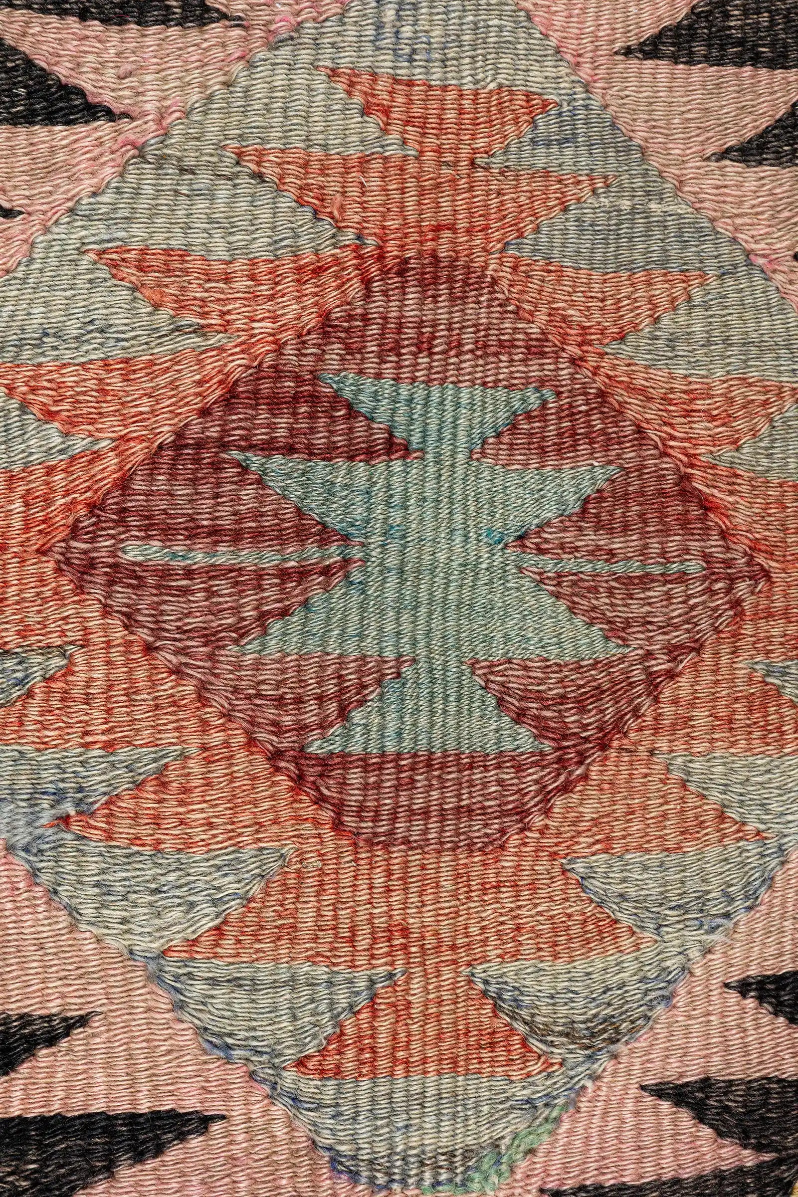 Detailaufnahme eines Rautenmotivs – feine Zickzack-Kanten in kontrastierenden Farben und dichter Webstruktur aus festem Wollgarn