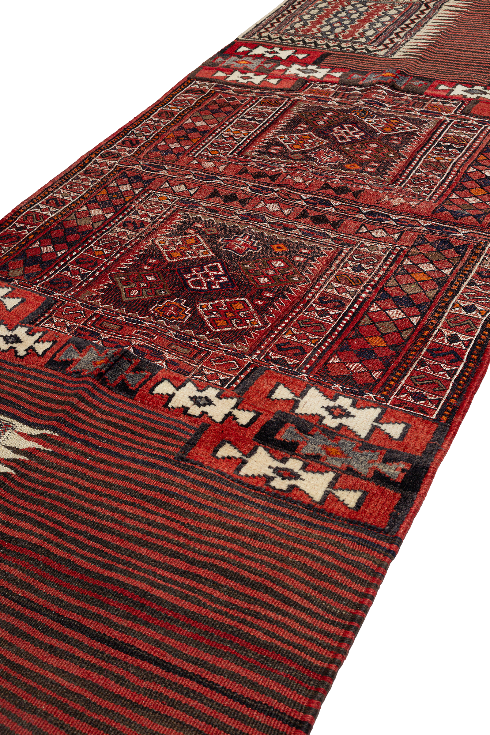 Seitlich aufgenommene Nahansicht mit Fokus auf weißen und schwarzen Hakenformen auf rotem Grund, angrenzend an fein gemusterte Bordüren mit Diamantmotiven und Rautenmusterungen in satten Rottönen.