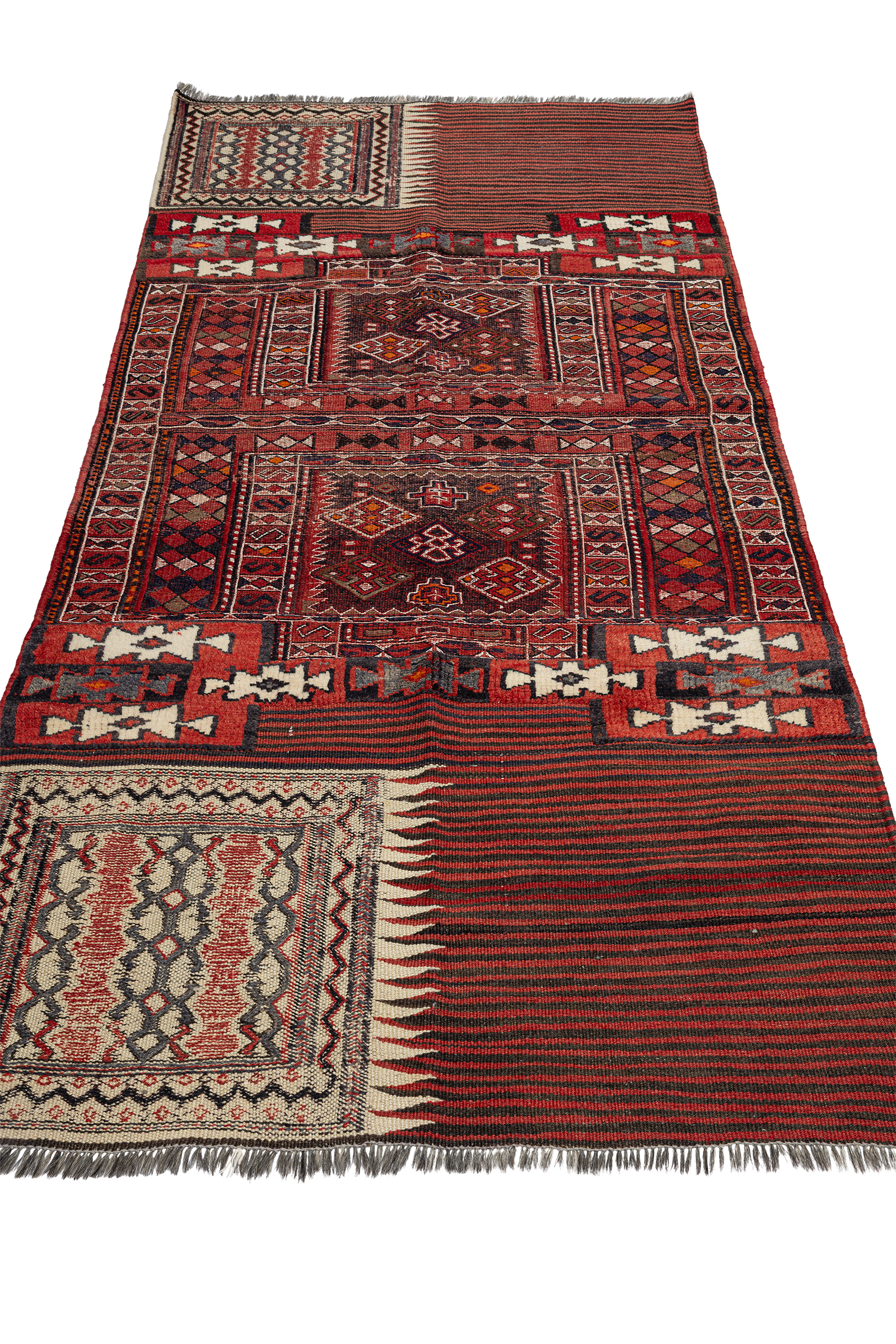 Schräg aufgenommene Ansicht des gesamten Kelims, beginnend mit dem vorderen gestreiften Abschnitt in Rot- und Schwarztönen, gefolgt von komplex gemusterten Hauptfeldern mit ornamentalen Rauten und verschachtelten geometrischen Linien.