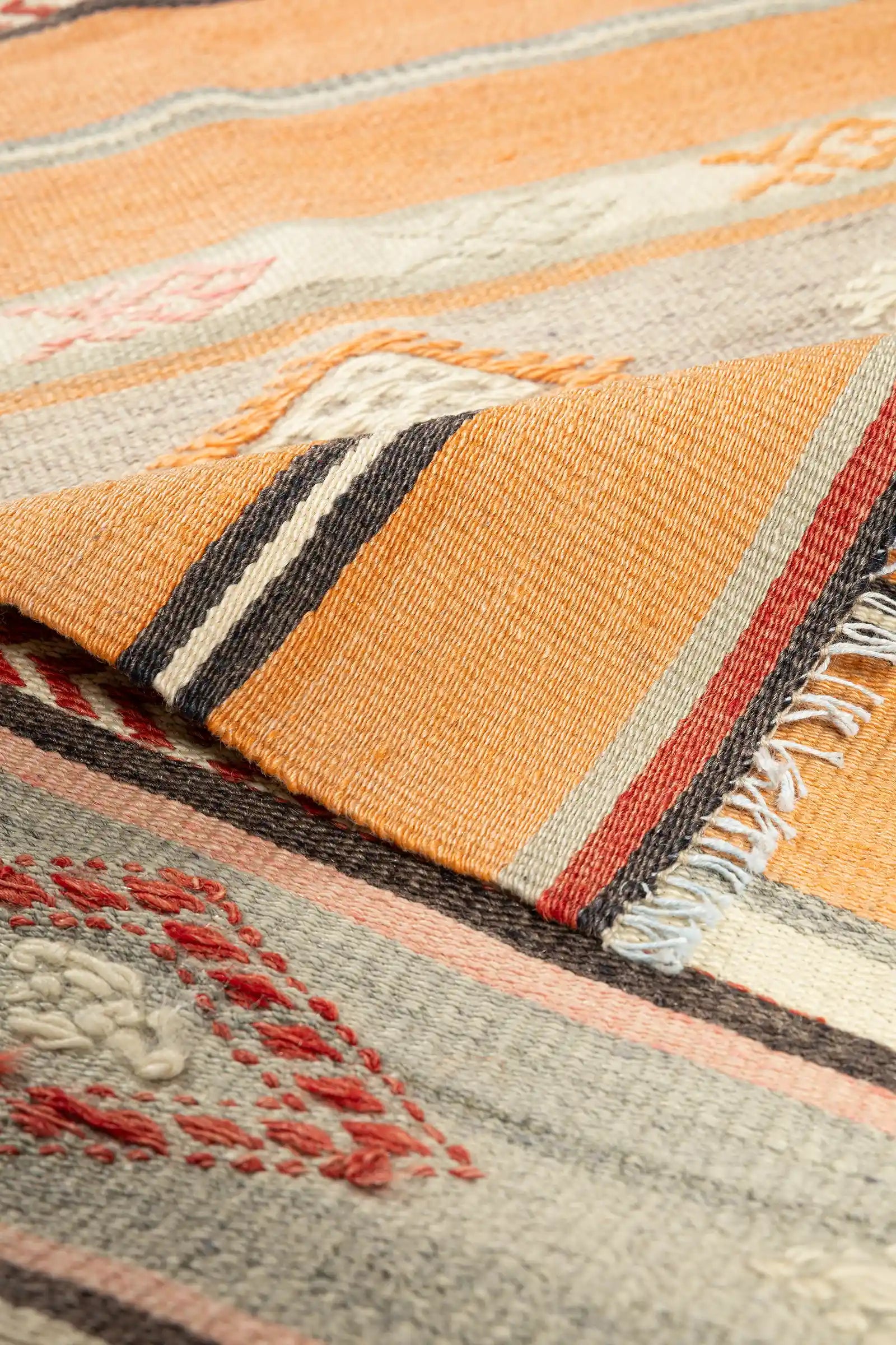 Vorder- und Rückseite des Kelims im Vergleich – Rückseite mit originalem Webbild, Abschluss mit kurzen, offenen Fransen