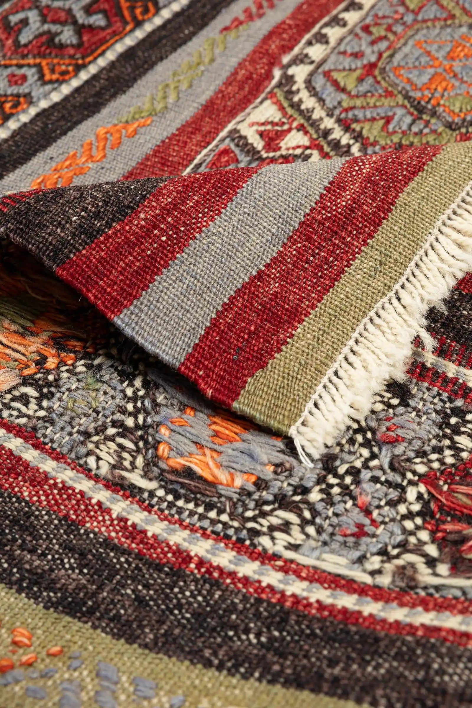 Vorder- und Rückseite im Vergleich – Rückseite flach gewebt und klar strukturiert, mit kurzen, hellen Fransenabschlüssen an beiden Enden