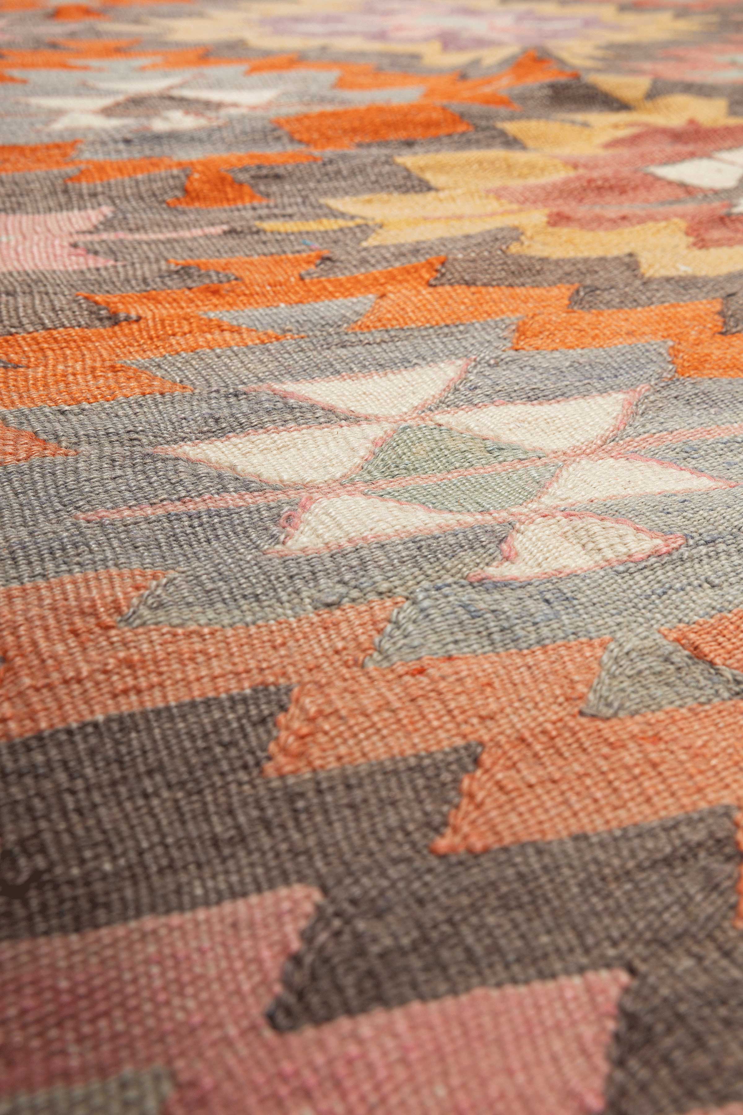 Detaillierte Ansicht der gewebten Oberfläche und feinen Haken- und Sternsymbole im traditionellen Stil