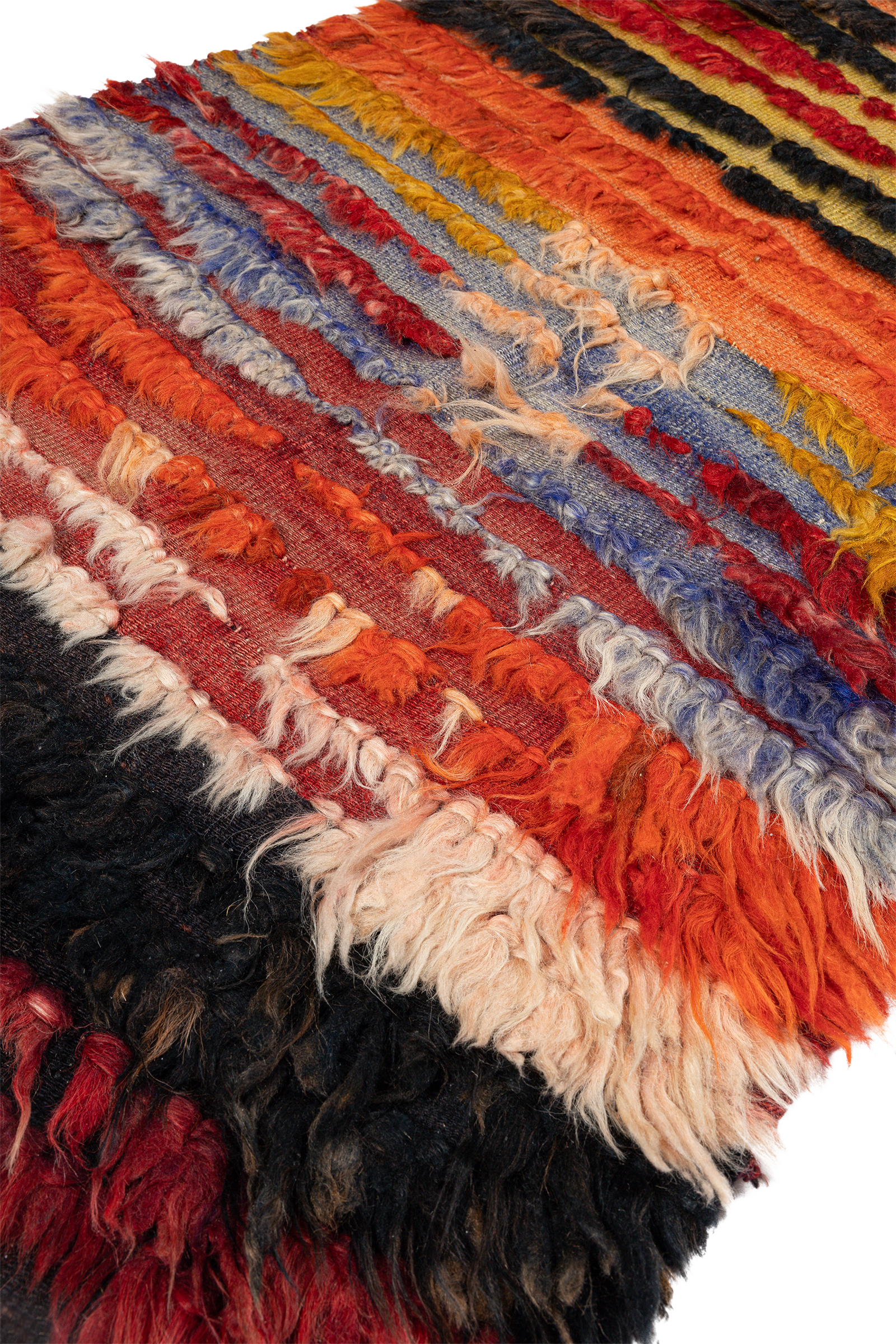 Seitlich aufgenommene Ansicht des Kilims mit hervorgehobenen Wollnoppen in gestaffelter Textur, klarer Blick auf das rustikale Farbspiel von Rot bis Cremeweiß.