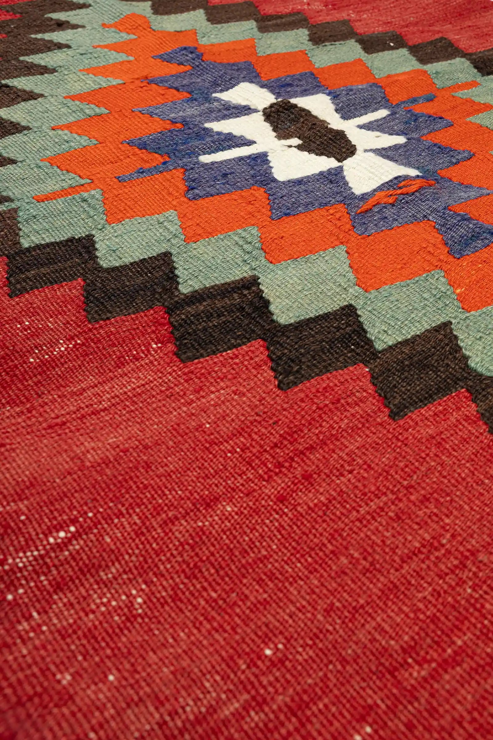 Nahaufnahme der Textur – dichte Flachwebung mit klar konturierten Farbfeldern, matte Wolloberfläche mit leichten Unregelmäßigkeiten