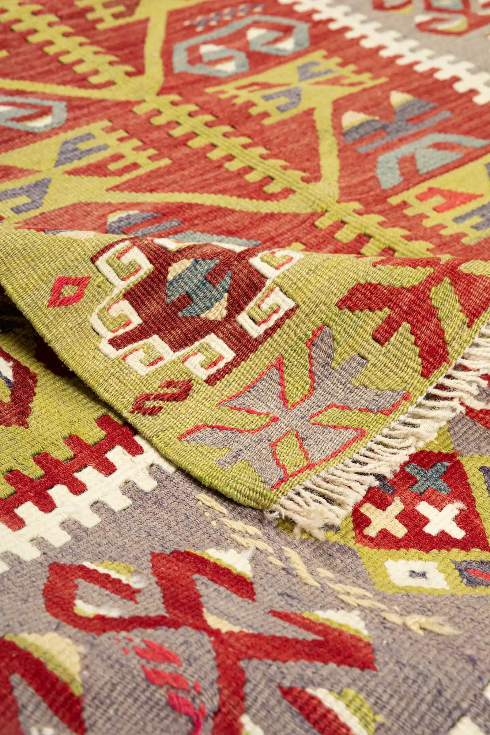 Vorder- und Rückseite im Vergleich – Rückseite mit spiegelbildlicher Struktur, kurze Fransen an den Schmalseiten in hellem Naturton