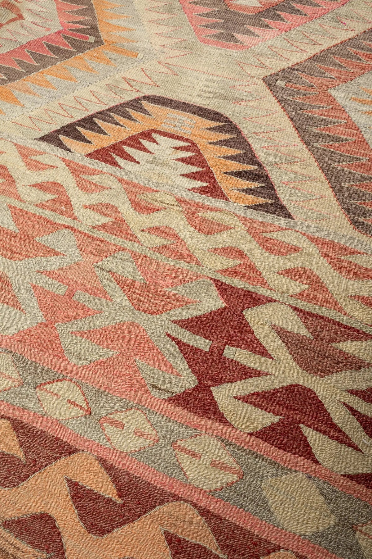 Wild Heart Free Soul Vintage Kelim aus Denizli mit geometrischen Mustern in Pink, Apricot und Erdtönen auf Creme.