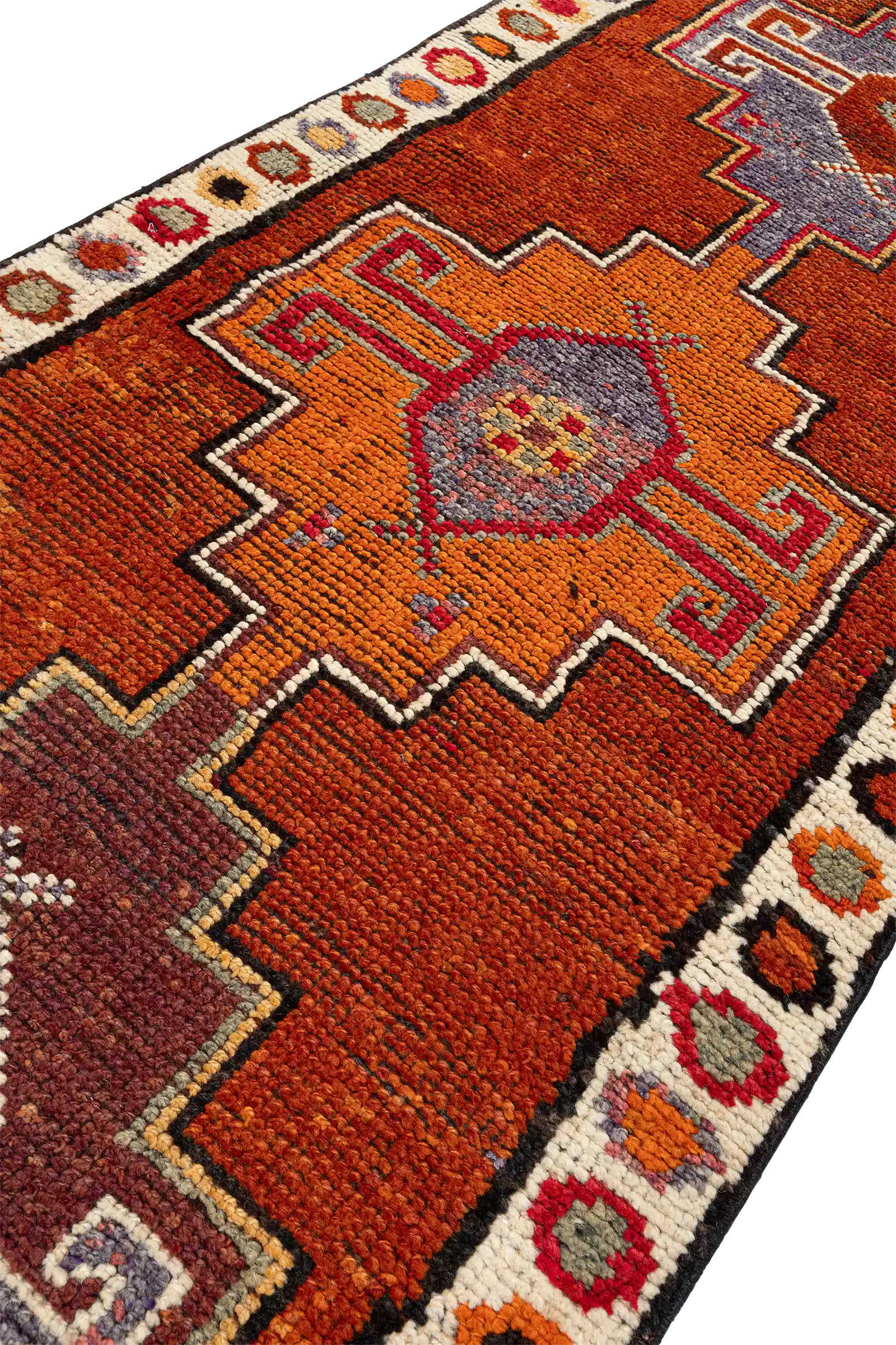 Seitlich geneigte Ansicht eines Motivsegments mit leuchtend orangefarbenem Zentralmuster auf rotbraunem Hintergrund, eingefasst von einem weißen Randstreifen mit regelmäßig angeordneten, farbigen Kreiselementen.