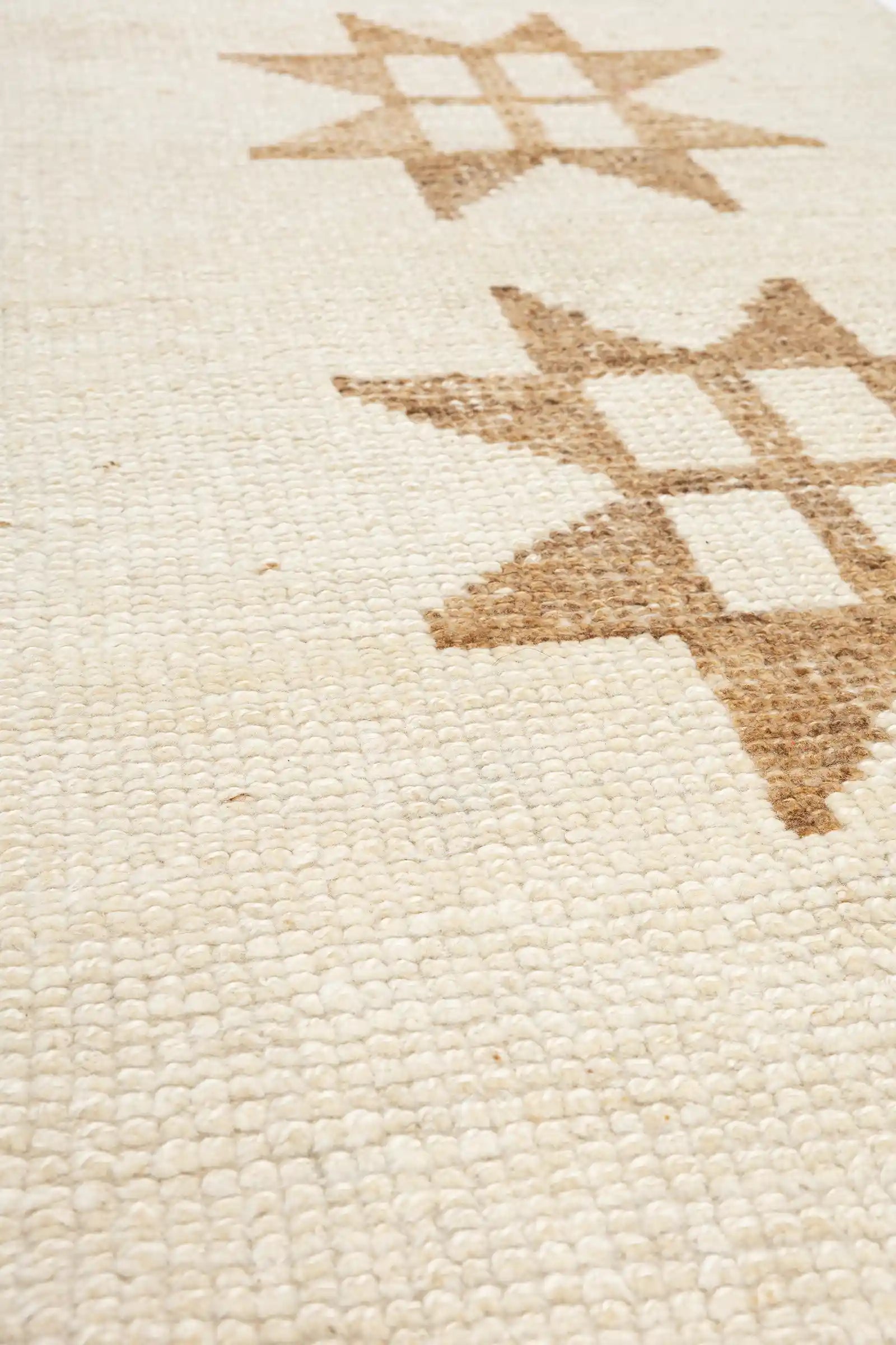 Ansicht der Wollstruktur mit dichter, grober Webung in hellen und mittelbraunen Nuancen, die das sternförmige Muster nachzeichnen.