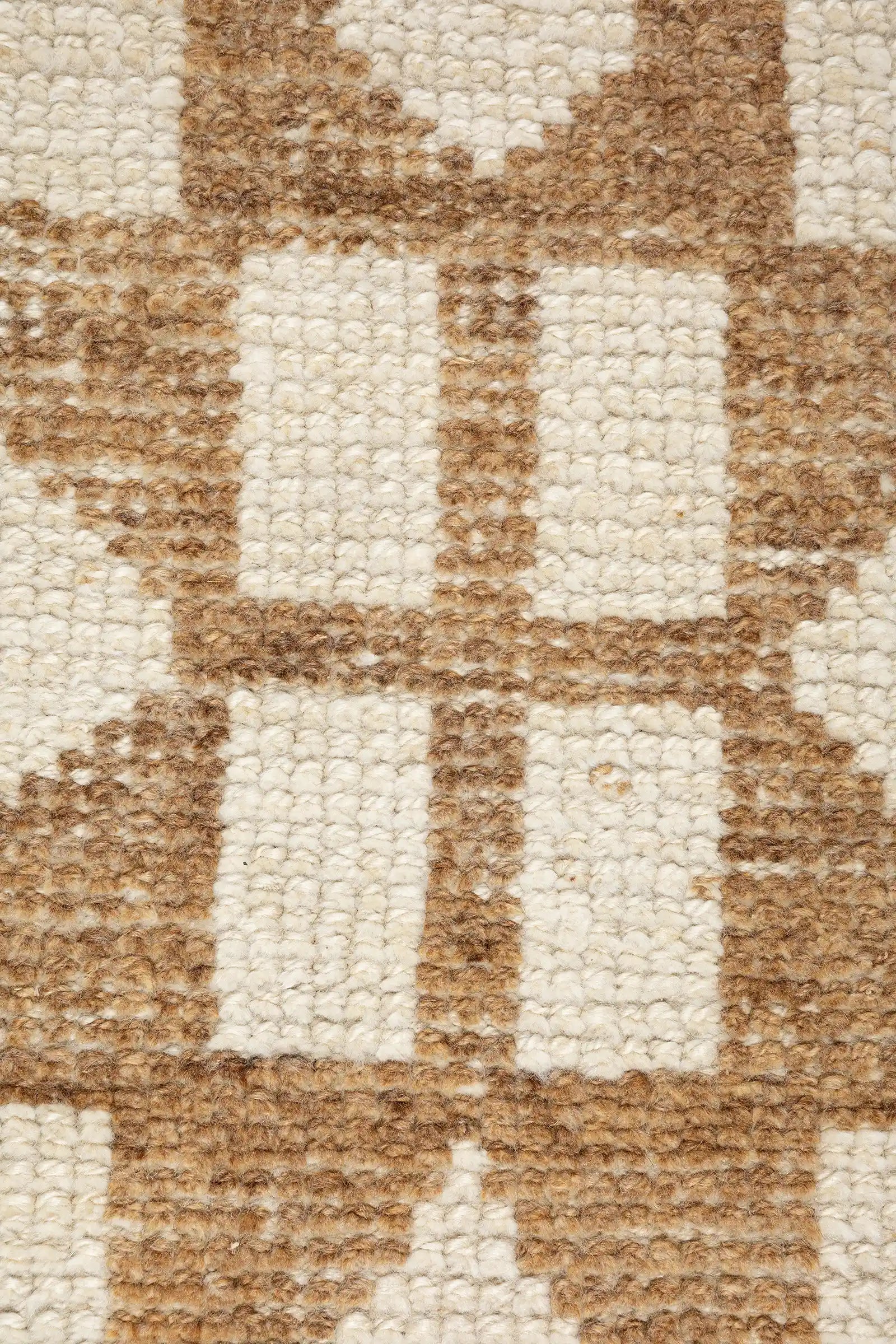 Zentrale Nahaufnahme eines achtzackigen Sternmotivs in hellem Braun mit eingewebten rechteckigen Elementen im Inneren auf beigem Grund.