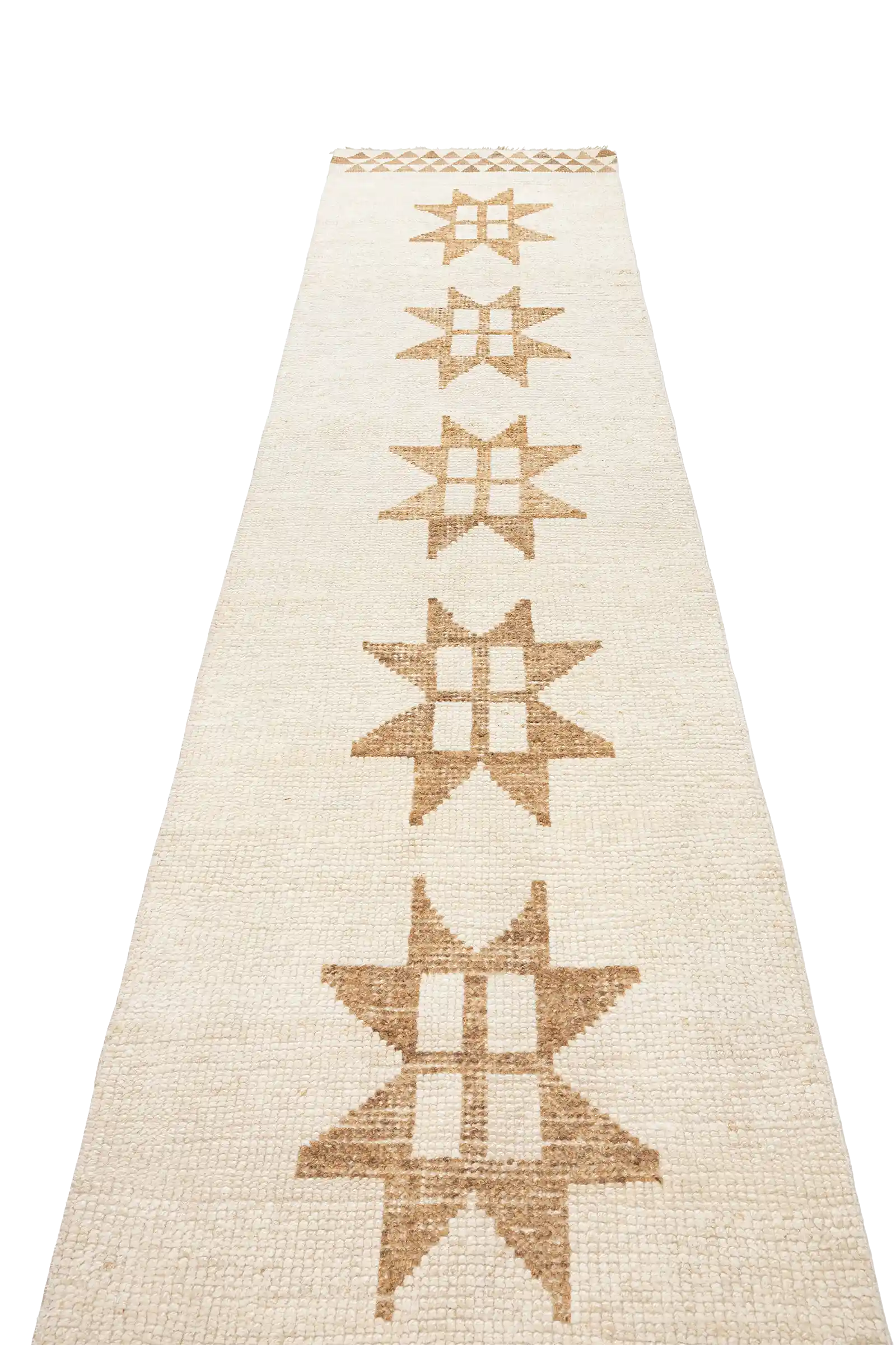Schräg aufgenommene Ansicht entlang der Längsseite des Teppichs, auf der mehrere gleichmäßig platzierte Sternmotive in warmen Brauntönen auf hellem Wollgrund sichtbar sind.