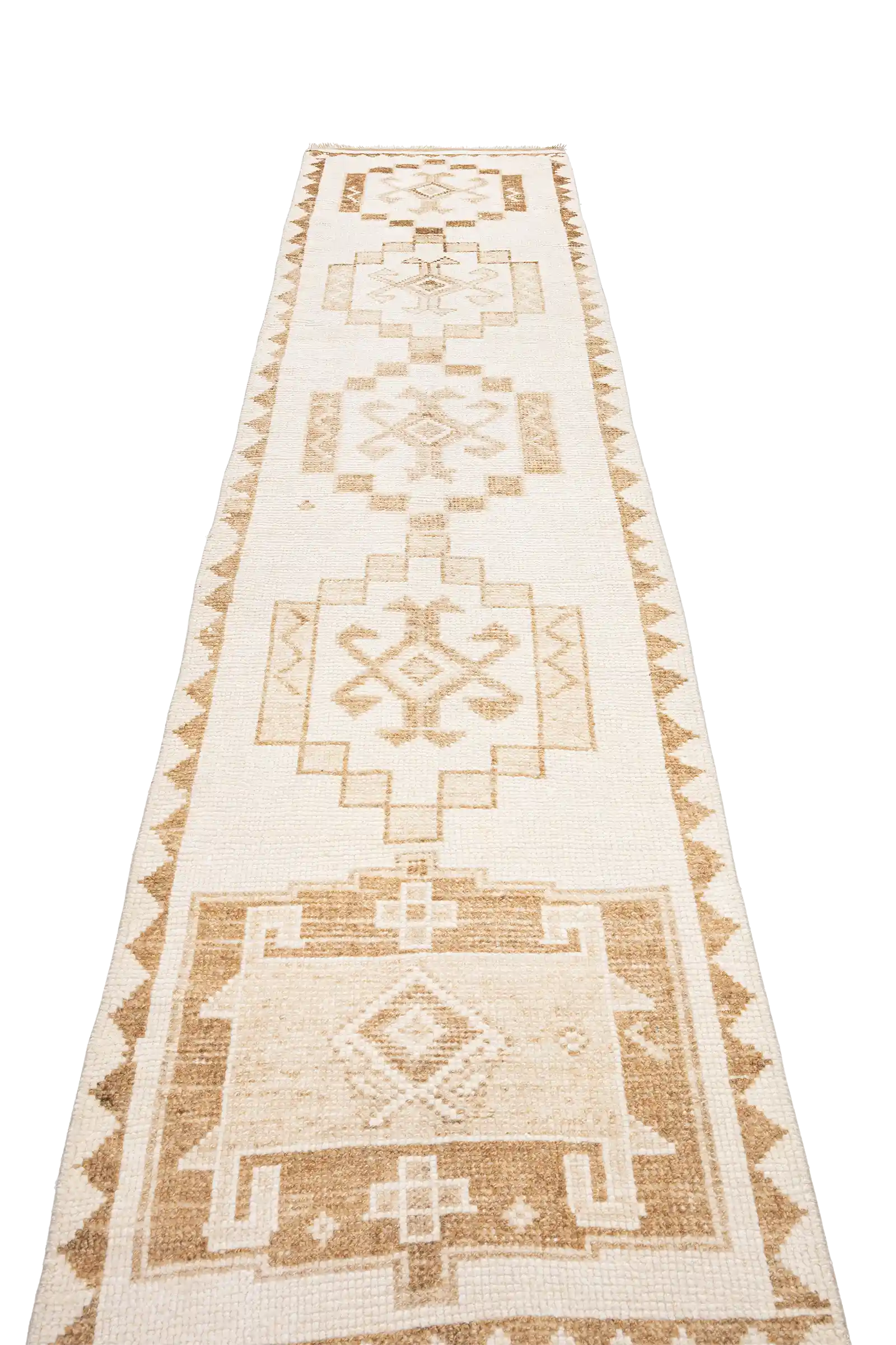 Schräger Blick entlang der Mittelachse des Teppichs mit mehreren rechteckig gerahmten Zentralmotiven, die in beigen Farbverläufen in den hellen Fond eingewebt sind.