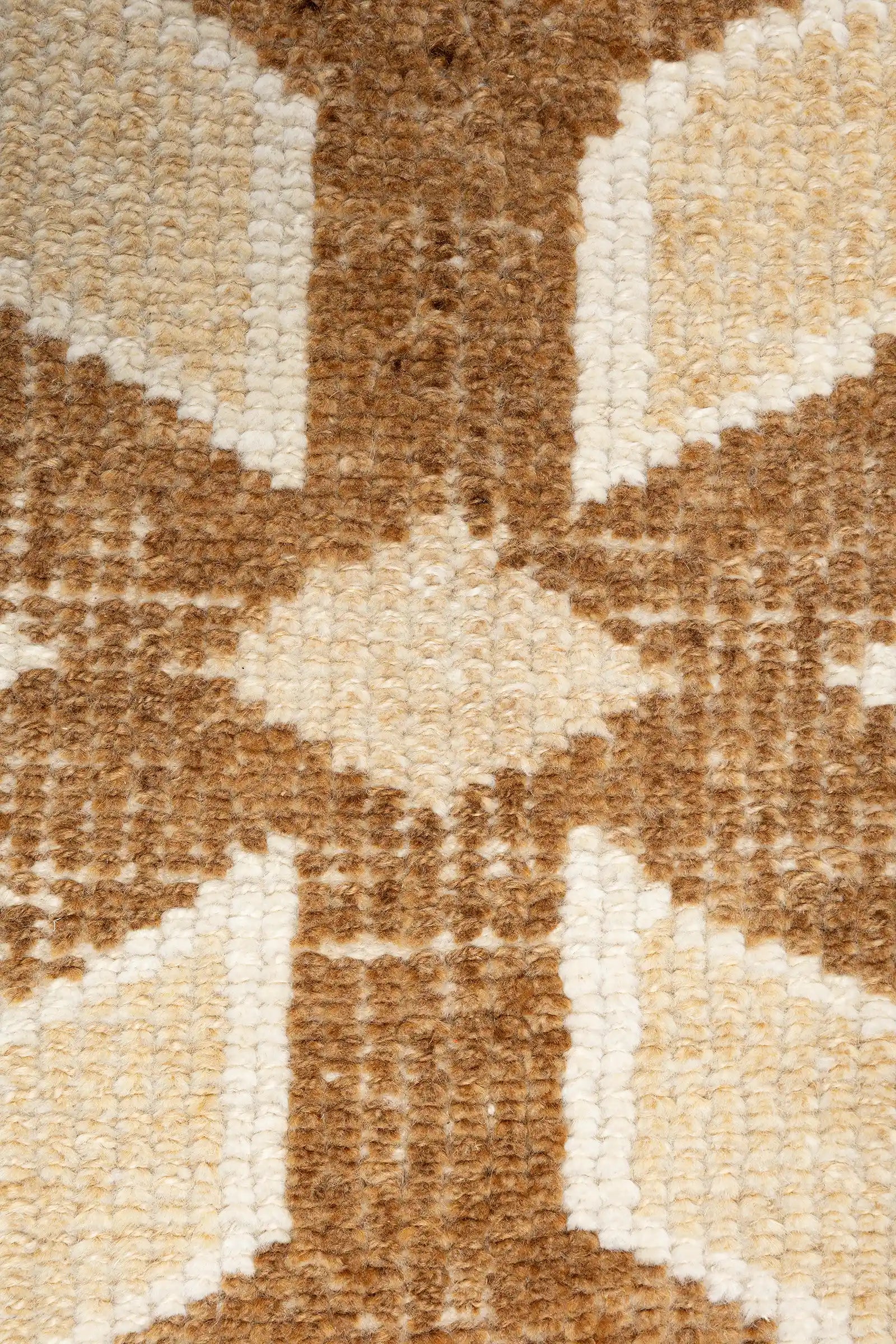 Nahaufnahme eines zentralen, sternähnlichen Kreuzmotivs in dunklem Beige mit rautenförmigem Zentrum, eingefasst von einem rechteckigen Rahmen in mittlerem Braun.