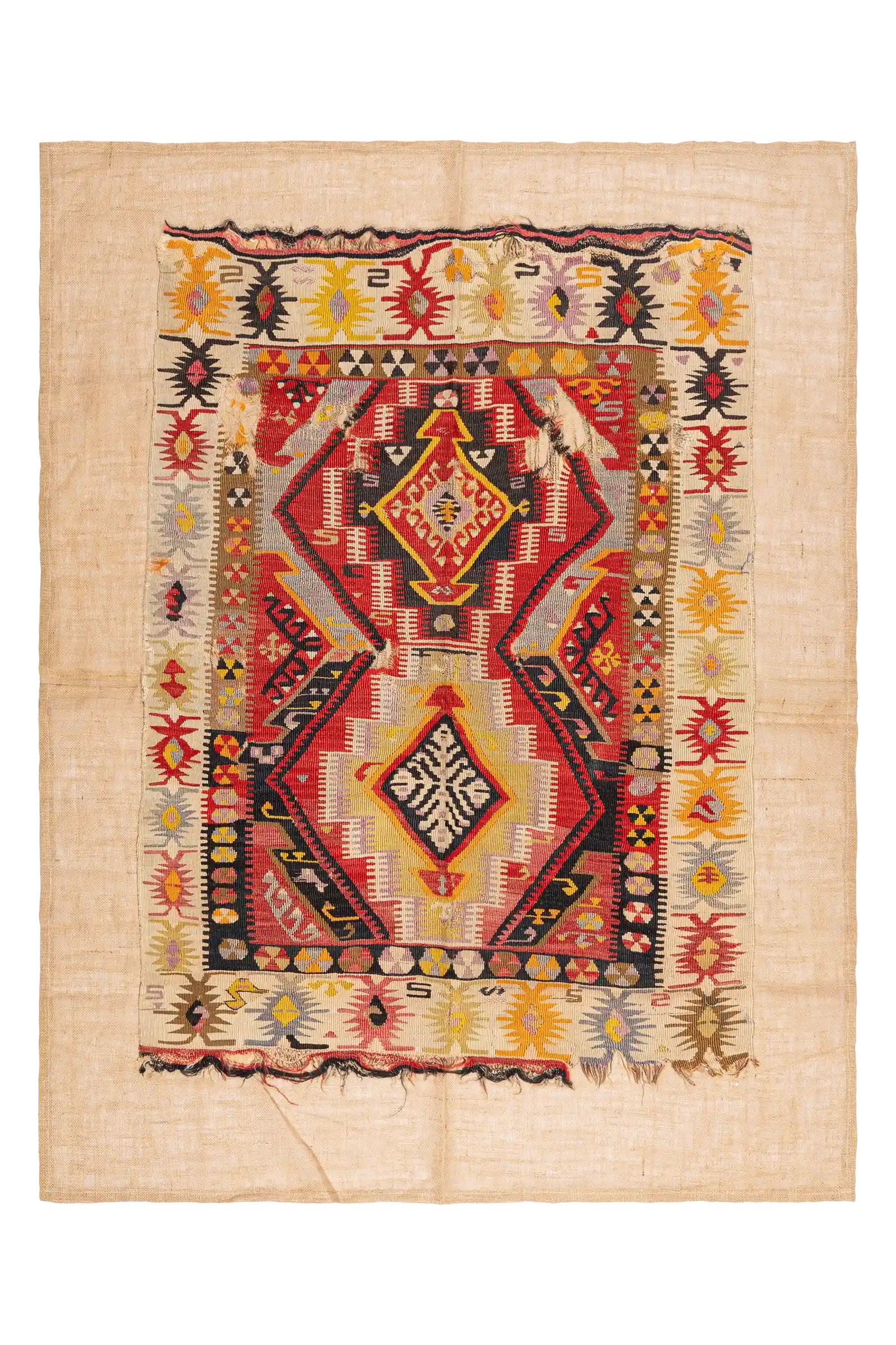 Rechteckiger Vintage-Kelim mit beigefarbenem Grundstoff, auf dem ein zentrales, farbintensives Panel aufgenäht ist. Die Webfläche zeigt zwei große, spiegelbildlich angeordnete Rauten in Rot, Gelb und Schwarz, umgeben von mehrfarbigen Bordüren mit gezackten Motiven und kleinen geometrischen Details. Die Ränder weisen Fransen und leichte Gebrauchsspuren auf.