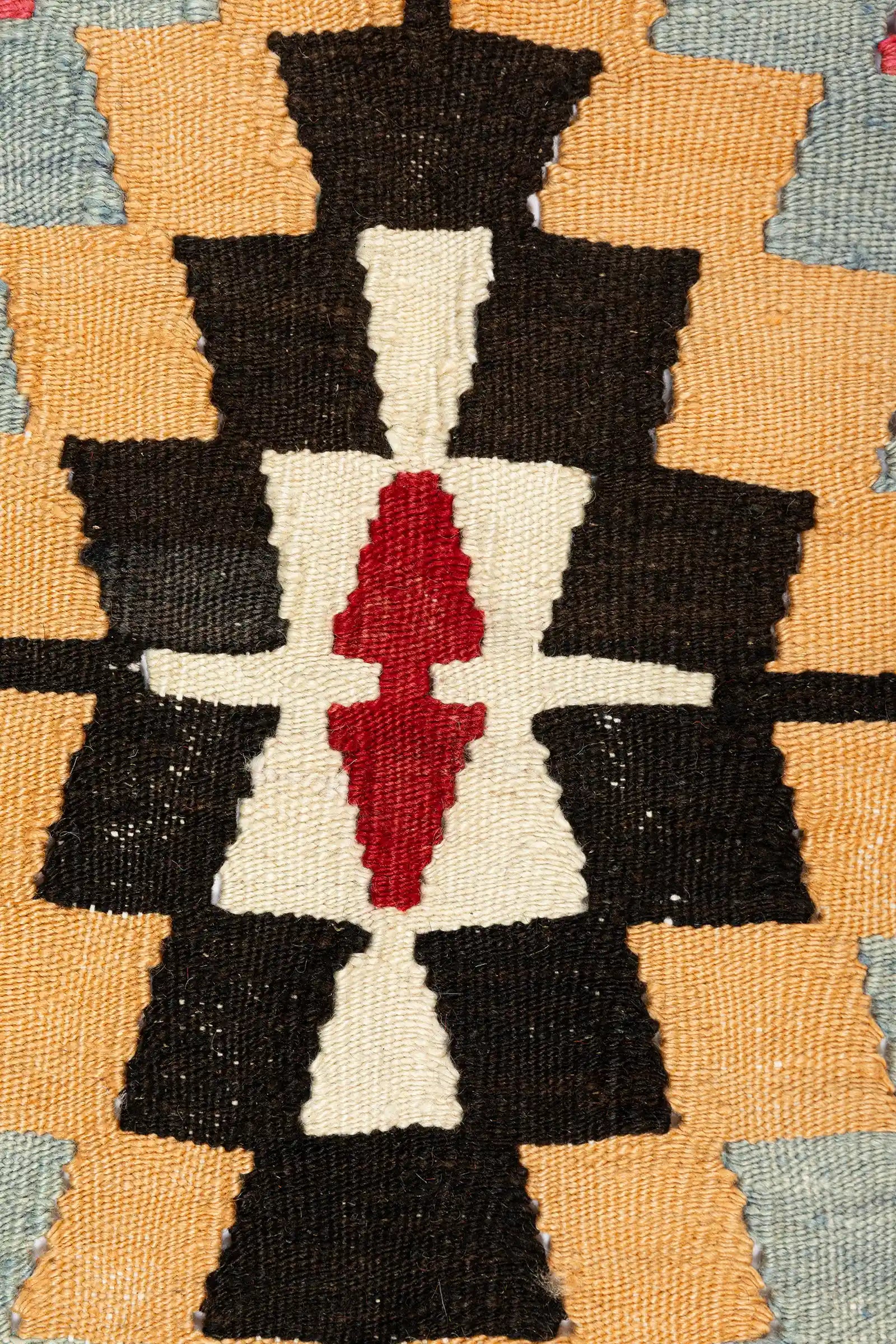 Detailaufnahme des Mittelmotivs – gezackte Raute mit kontrastierenden Farben wie Schwarz, Salbeigrün, Blassblau und Gelb