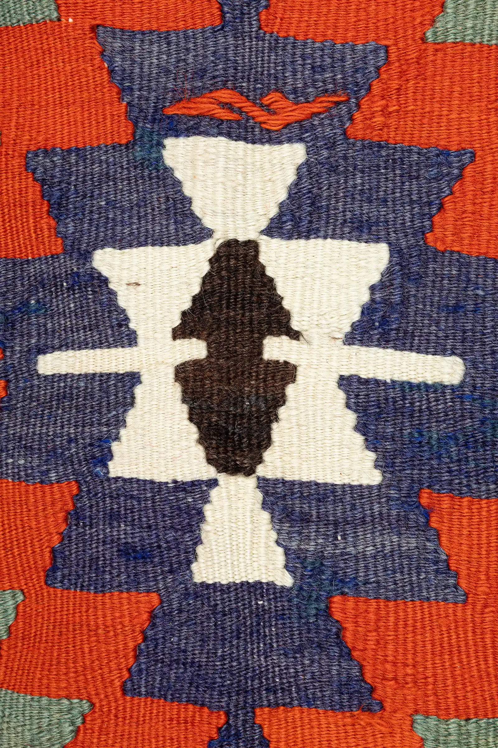 Detailaufnahme des Mittelfelds – präzise gewebte Farbflächen in geometrischer Abstufung, mit zentralem schwarz-weißen Zentrum und kontrastierenden Blöcken in Violett und Orange